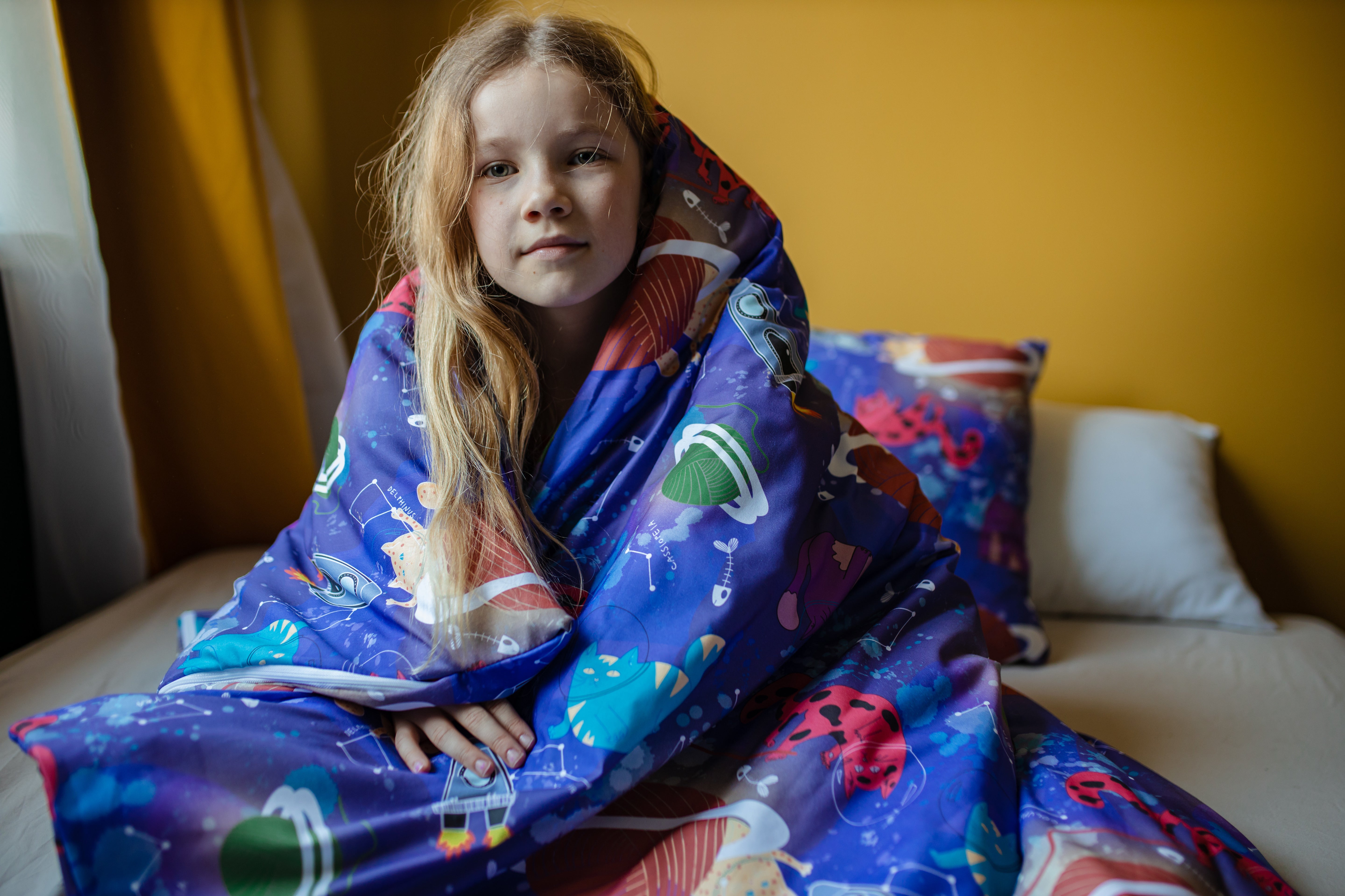 Enfant apaisé enveloppé dans sa couverture lestée à motif espace