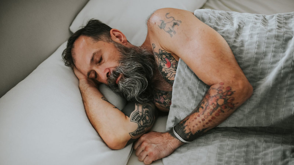 Homme endormi sous une couverture lestée grise plutôt qu'une couverture classique