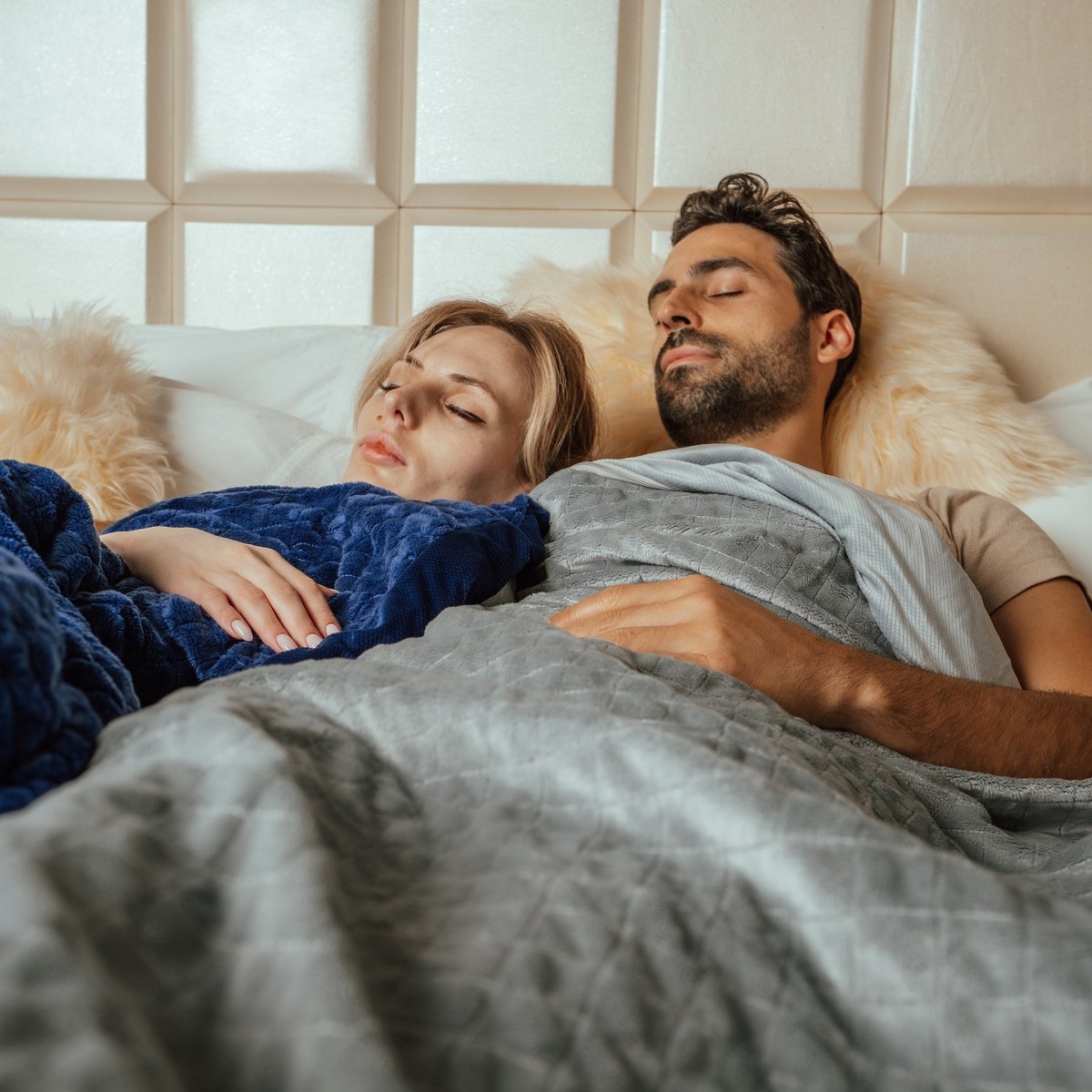 Couple endormi chacun sous sa couverture lestée