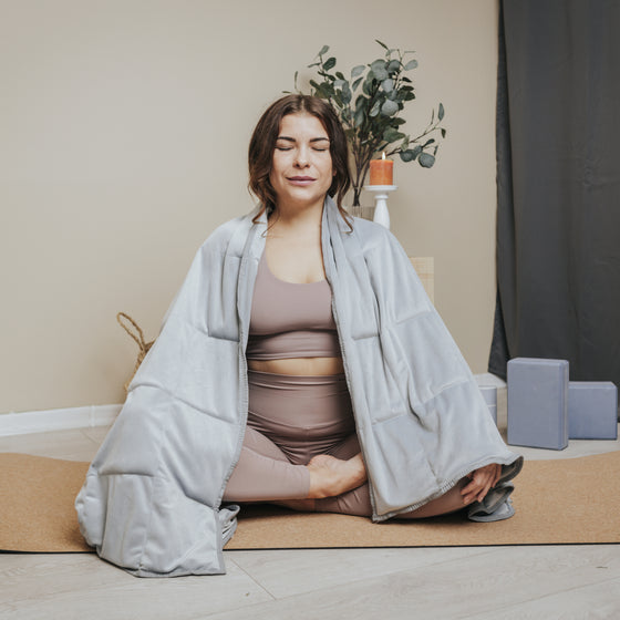 Femme en méditation avec la couverture lestée de yoga