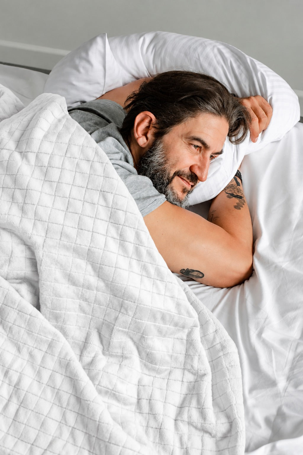 Couverture lestée Balance® Blanche sur un lit, chambre de jour