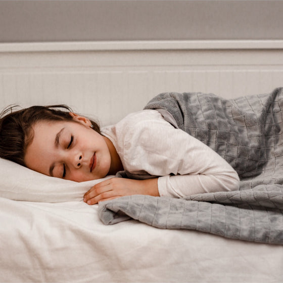 Enfant endormi sous une couverture lestée pour enfant