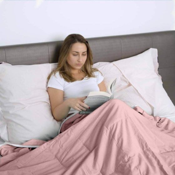 Femme qui lit sous une couverture lestée rose