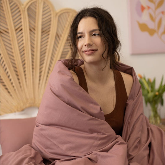 Femme enveloppée dans une couverture lestée vieux rose