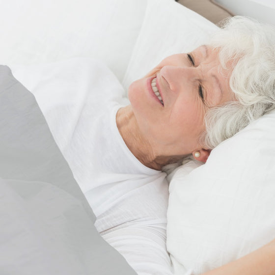 Grand-mère endormie paisiblement sous une couverture lestée