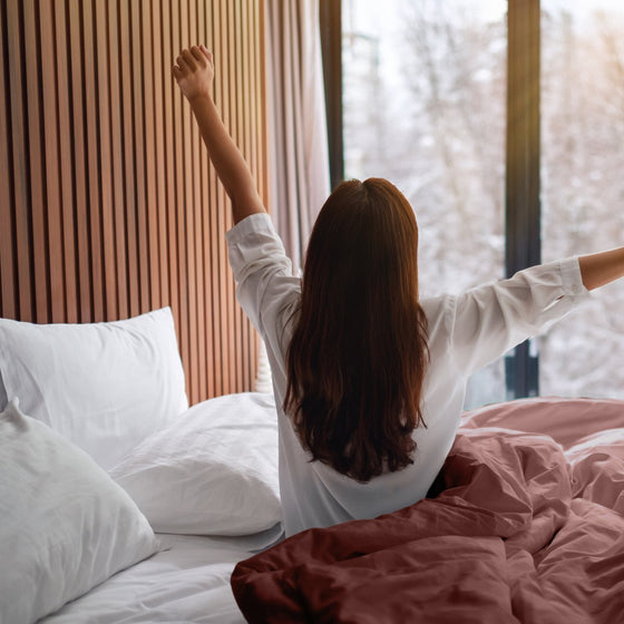 Réveil du matin avec un plaid lesté terracotta au pied du lit