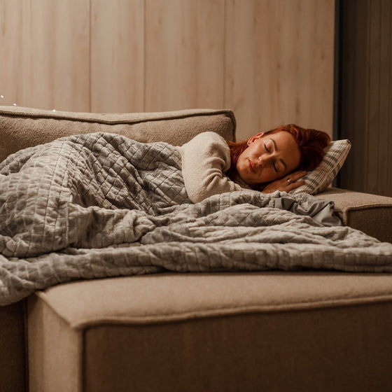 Femme endormie sous une couverture lestée dans une chambre chaleureuse