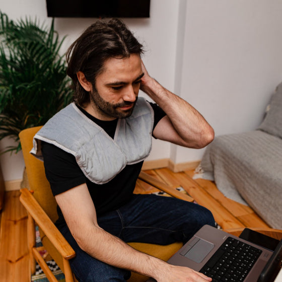 Homme en télétravail avec un châle lesté sur les épaules